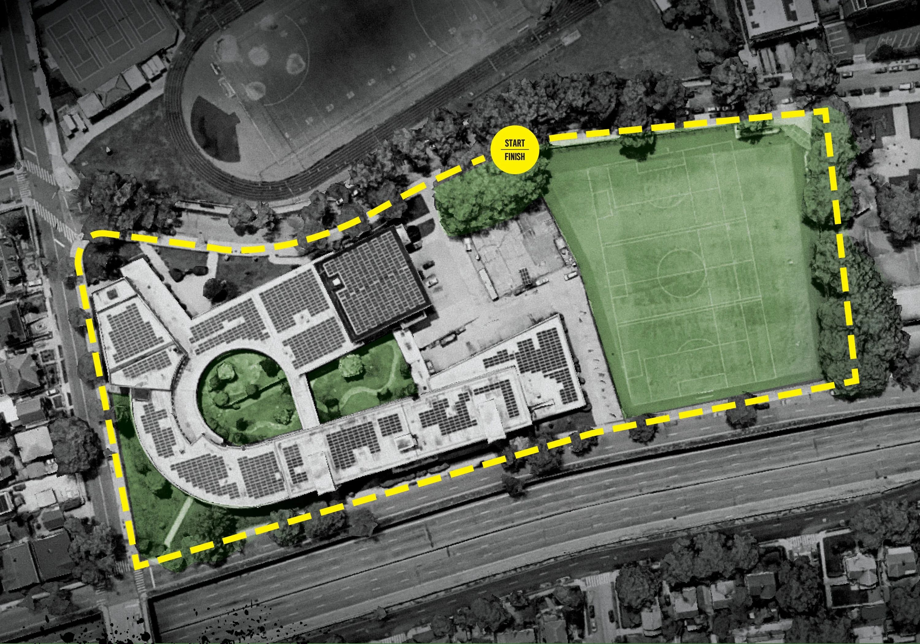 Aerial view of a building and sports field bordered by a yellow dashed line.