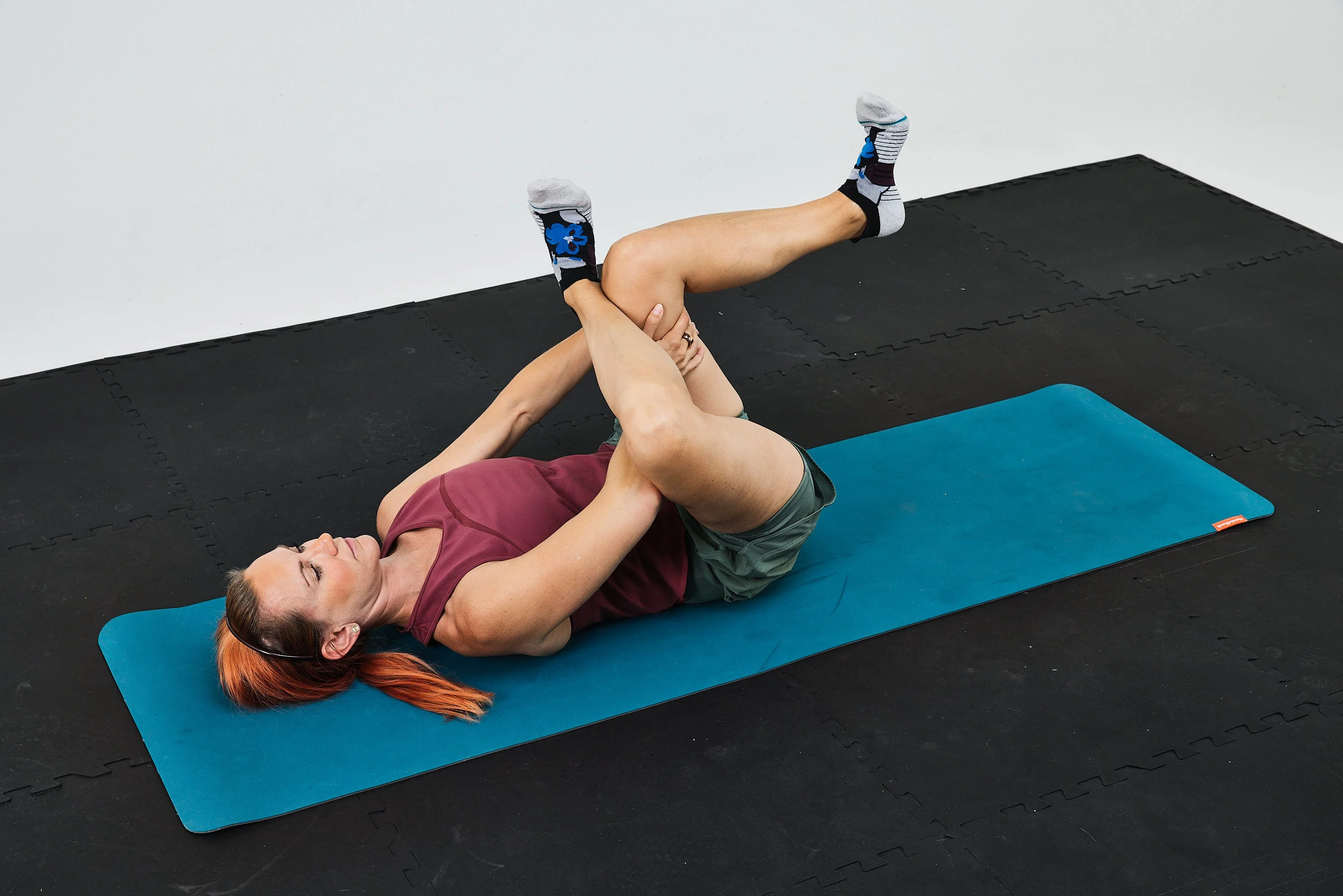 Woman performing a stretching exercise on a yoga mat in a fitness setting. Woman performing a stretching exercise on a yoga mat in a fitness setting.